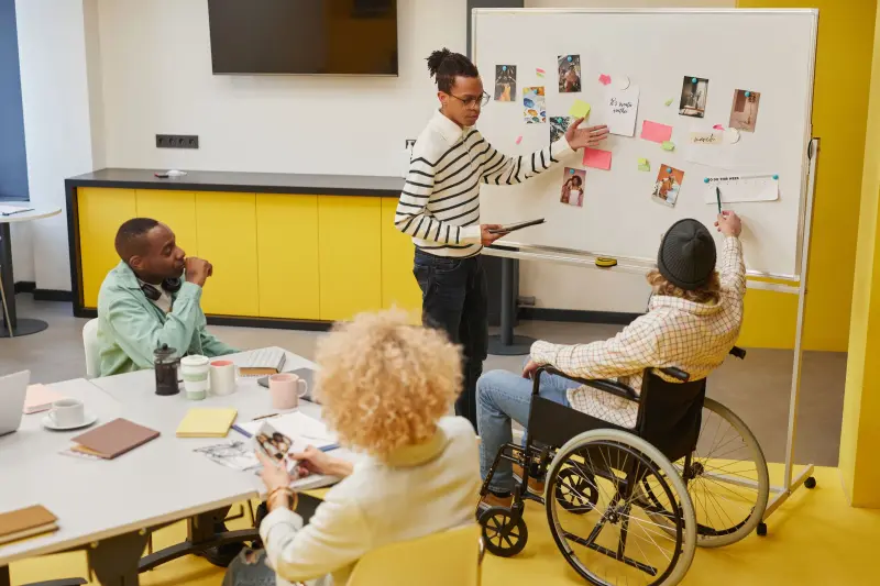 A team planning together at a whiteboard covered in sticky notes
