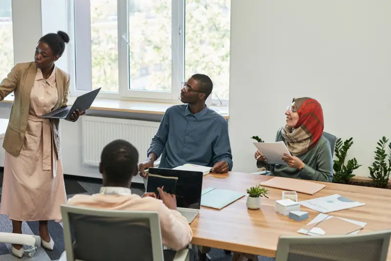 A facilitator presenting to a small team around a meeting table