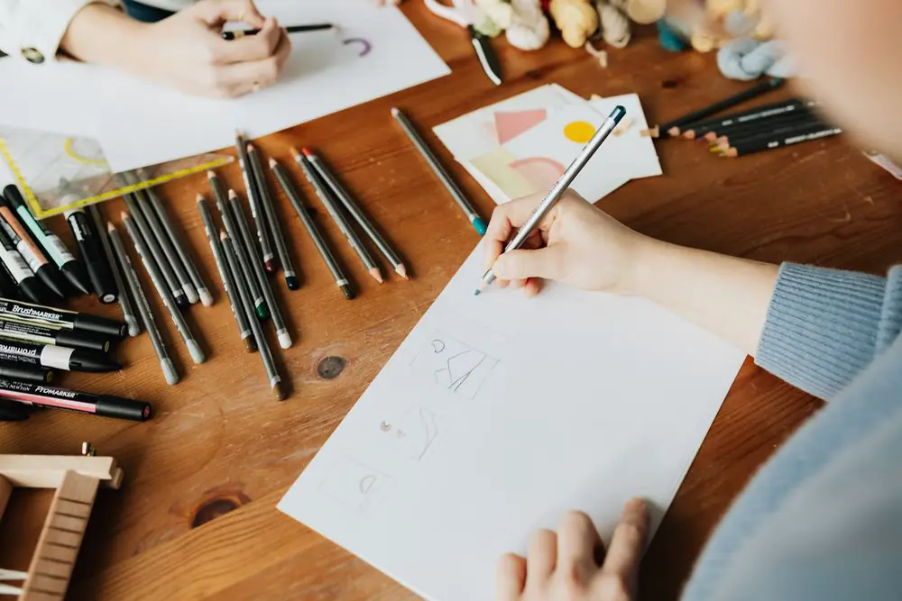 Pencil sketches on paper at a wooden table