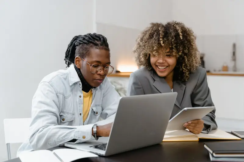 Two colleagues working through a plan together at a laptop